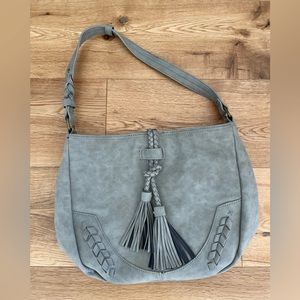 Gray hobo shoulder bag with fringe detail.